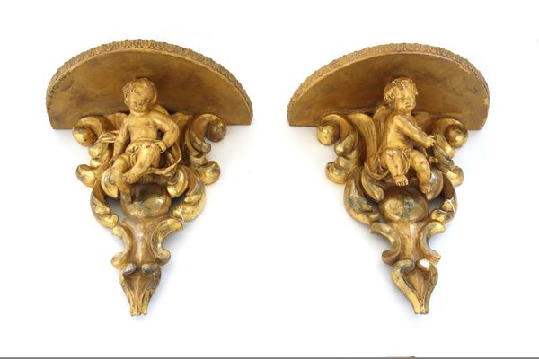 A pair of Louis XV style giltwood wall brackets, late 20th century, each carved with a putto against a pierced shell backplate, 32.5cm high. (2)
