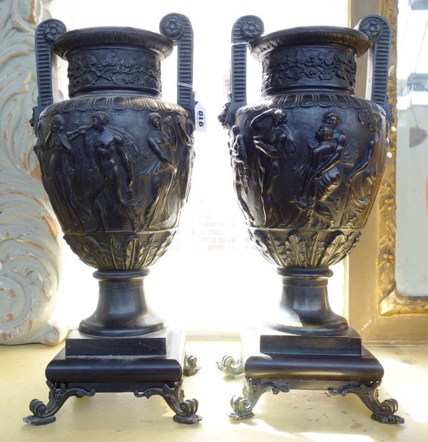 A pair of patinated bronze two handled urns, 20th century, each of Grecian revival style, relief cast with a band of classical figures, on a square ba