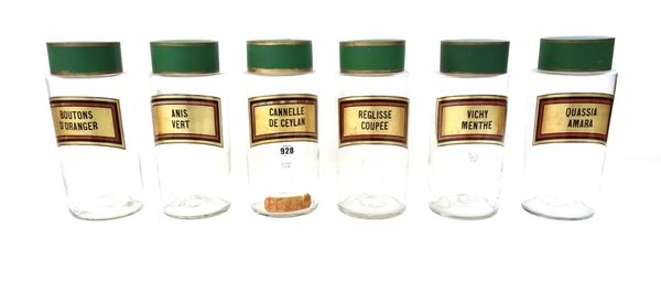 A set of six glass storage jars, early to mid-20th century, with green tin lids, each with gilt French lettered label, 27cm high. (6)