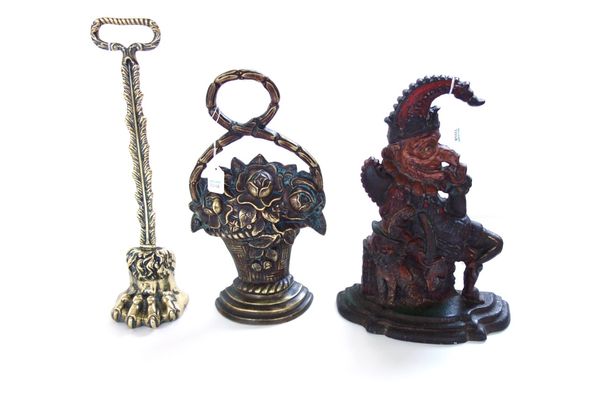 A Victorian polychrome painted cast iron 'Punch' doorstop, 31cm high, a Victorian brass lions paw doorstop with loop handle, and a similar basket of f
