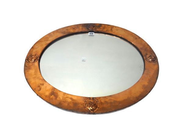 A Liberty & Co Arts and Crafts copper mirror, early 20th century, of oval form, decorated with four applied studded roundels, 63cm wide, together with