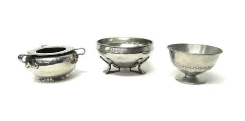 Three Tudric pewter footed bowls, circa 1900, comprising; a round shaped tri-handled bowl, 13cm diameter, a bowl decorated with geometric band motif t