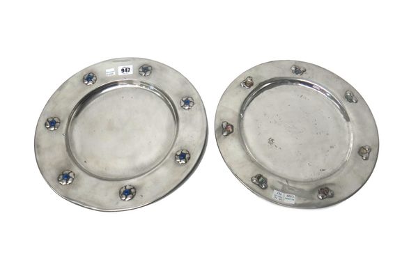 Two pewter chargers, circa 1900, one decorated with seven abalone shell hearts to the border, 32.5cm diameter, the other worked in relief with seven f