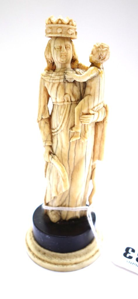 An ivory carving of the Madonna and child, 17th century and later, on a later ebony and ivory plinth (a.f), the figure 10.5cm high.