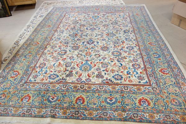 An Indian carpet, the ivory field with an allover floral design and sage palmette and vine border, 376cm x 271cm.
