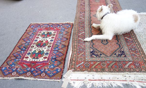 A Hamadan runner, Persian, the madder boteh border with three indigo diamond medallions, shaped surround, a madder leaf and rosette border, 313cm x 95