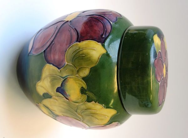 A Moorcroft 'Anemone' ginger jar and cover decorated with a band of flowers against a green ground, impressed marks 20cm high.
