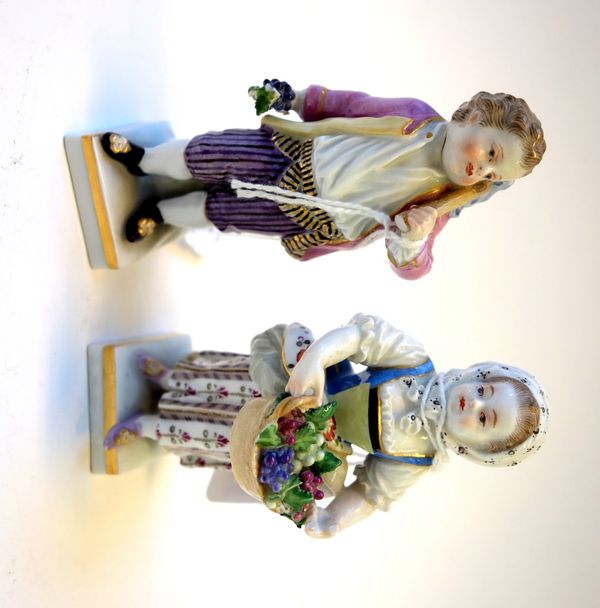 A pair of Meissen porcelain figures, late 19th century, both in period dress and harvesting produce, on a square base, with blue crossed swords marks