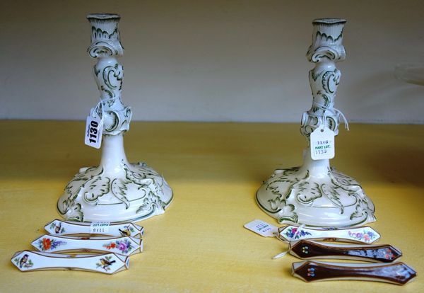 A pair of Nymphenberg porcelain candlesticks, 20th century, foliate moulded green against a cream ground, with printed and impressed marks, 20cm high,