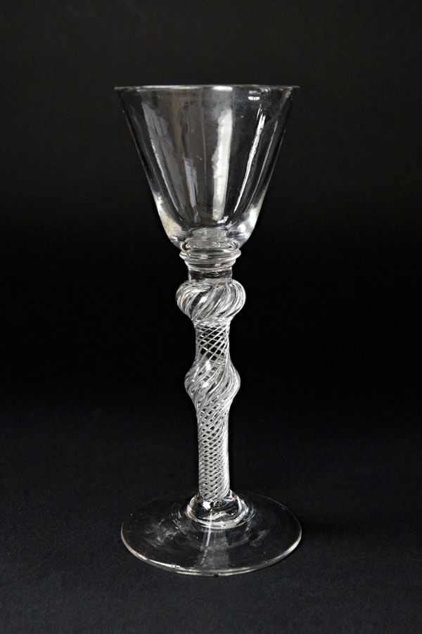 A mid 18th century wine glass, with rounded bell bowl and double knopped air twist stem, 16.2cm high. Illustrated.