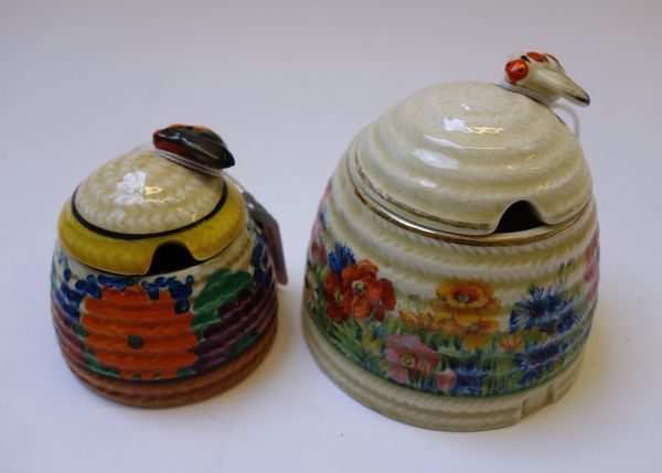 A Clarice Cliff beehive preserve pot and cover, decorated in the 'Gay Day' pattern, 7cm high, and one further Clarice Cliff beehive preserve pot and c