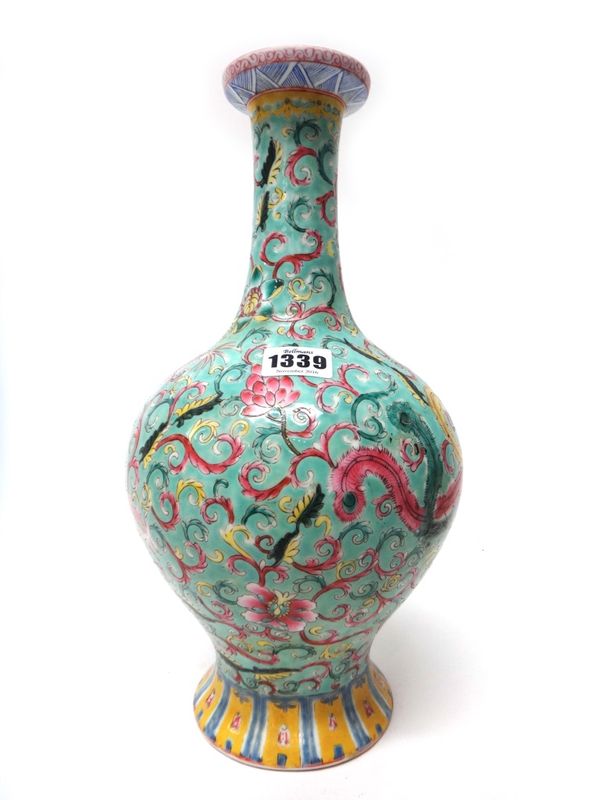 A Chinese famille-rose baluster vase, circa 1900, painted with a dragon and phoenix amongst flowers and foliage against a green ground, apochryphal Qi