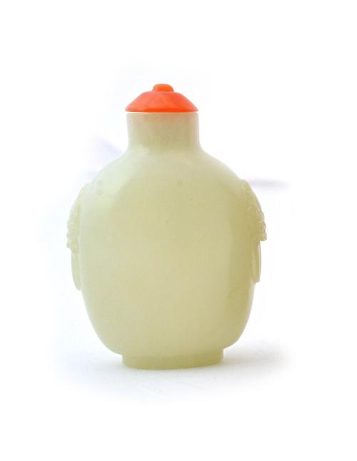 A Chinese jade snuff bottle, 19th century, of ovoid form, carved with lion mask and ring handles, 6cm. high. Illustrated.