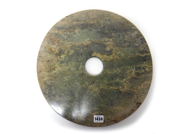 A very large jade bi disc, of plain circular form, the stone of green tone with brown, cream and grey inclusions, 39cm.diameter.