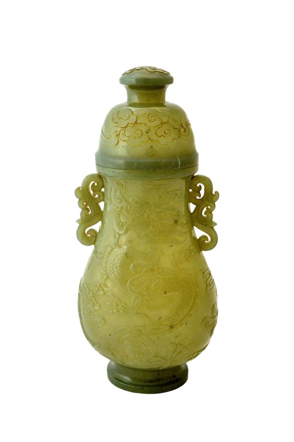 A Chinese jade pear shaped two-handled vase and cover, 19th century, each side carved with a writhing dragon, the domed cover with cloud scrolls, set
