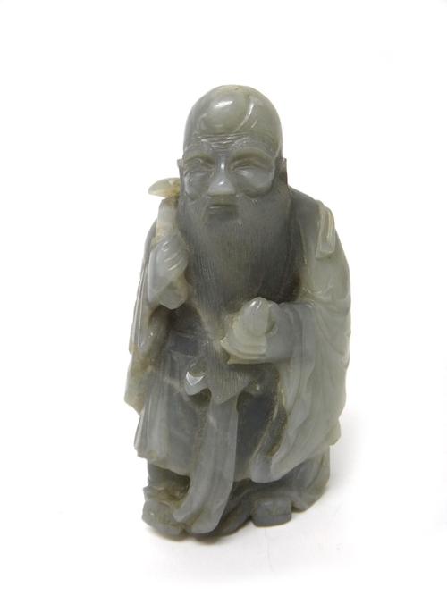 A Chinese jade figure of Shoulao, probably 19th century, carved standing holding a peach and ruyi sceptre, the stone of bluish grey tone, 12cm. high.