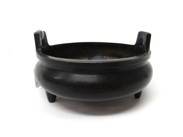 A Chinese bronze censer, six character Xuande mark but later, compressed form with two upright handles, raised on three peg feet, 15cm.diameter.