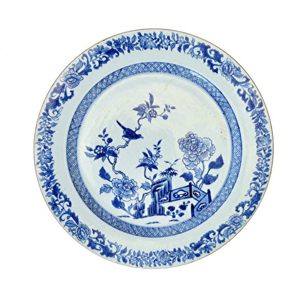 A large Chinese export blue and white dish, 18th century, painted in the centre with a bird perched on flowering branches in a fence garden, inside a
