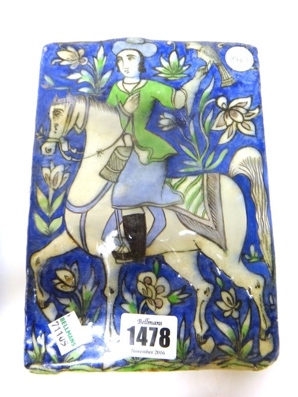 A Qajar pottery rectangular tile, late 19th century, moulded and painted with a falconer on horseback, (a.f), 20cm. by 14.5cm.