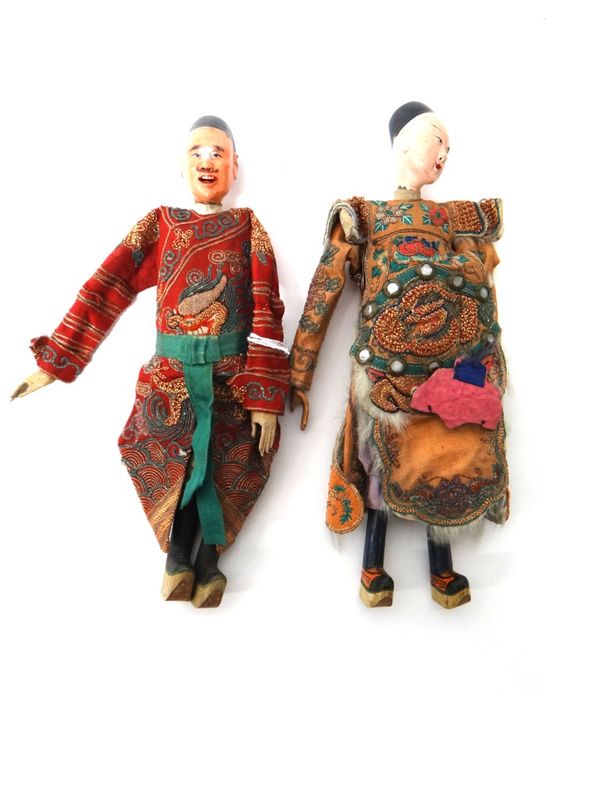 A pair of Chinese dolls, late 19th century, each with a painted head, wooden lower legs and feet and wearing embroidered robes, each approx. 26.5cm.ta