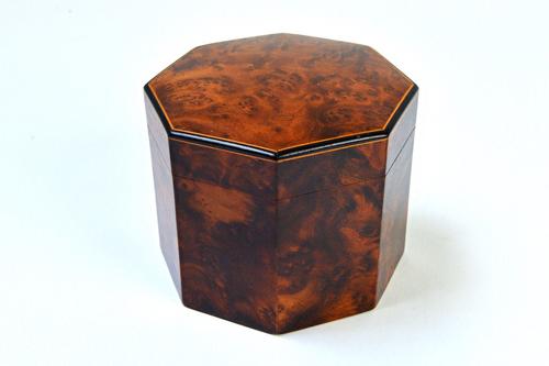 A 19th century ebony and boxwood strung amboyna octagonal tea caddy, 12cm wide. Illustrated.