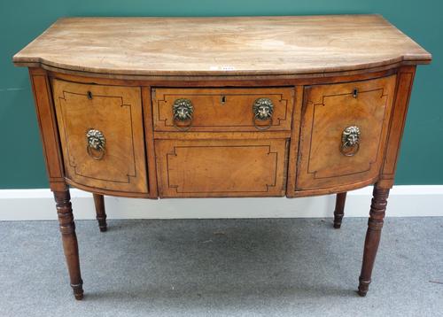 An early 19th century small mahogany bowfront sideboard with an arrangement of three drawers and a cupboard, on turned supports, 107cm wide.