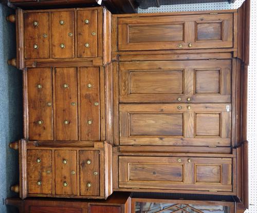 A George III pine housekeeper's cupboard, the inverted breakfront with four double panel cupboards over a nine drawer base, 168cm wide x 210cm high.