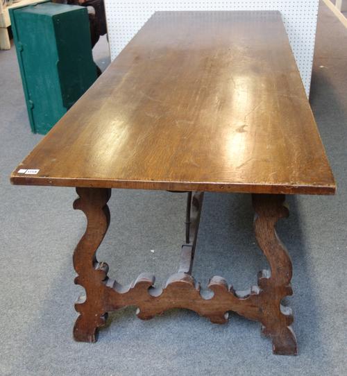 A Spanish oak refectory dining table on shaped end supports, united by wrought iron stretcher, 83 x 229cm long.