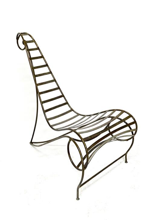 After Andre Dubreuil; a 20th century metal 'spine' chair, 62cm wide x 108cm high. Illustrated.