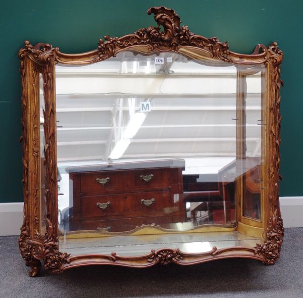 A 19th century Venetian carved giltwood wall mounted vitrine, with glazed door and swept back sides, 105cm wide.