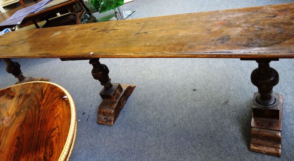 A 17th century and later Italian walnut and beech serving table, the single plank top on four block and turned supports, 55cm wide x 316cm long.