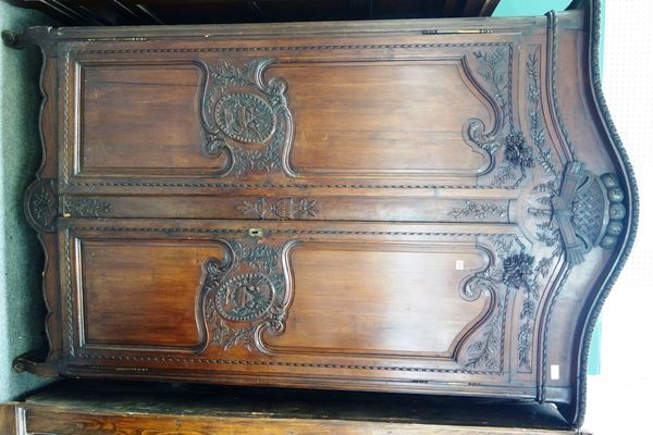 A 19th century French carved and stained pine two door armoire, on squat cabriole supports, 154cm wide x 240cm high.