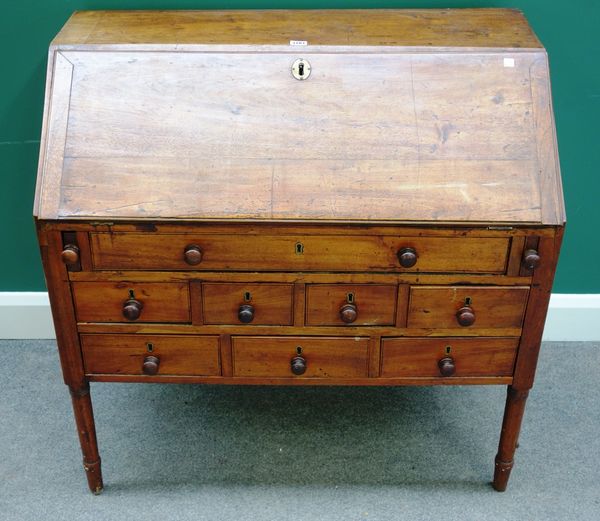 An 18th century provincial French fruitwood bureau, the fall enclosing a fitted interior over an unusual arrangement of eight drawers, on turned suppo