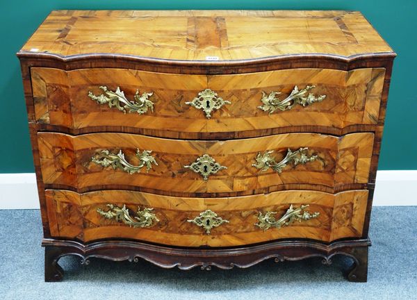 A 18th century German walnut serpentine three drawer commode, with carved frieze, on bracket feet, 102cm wide.