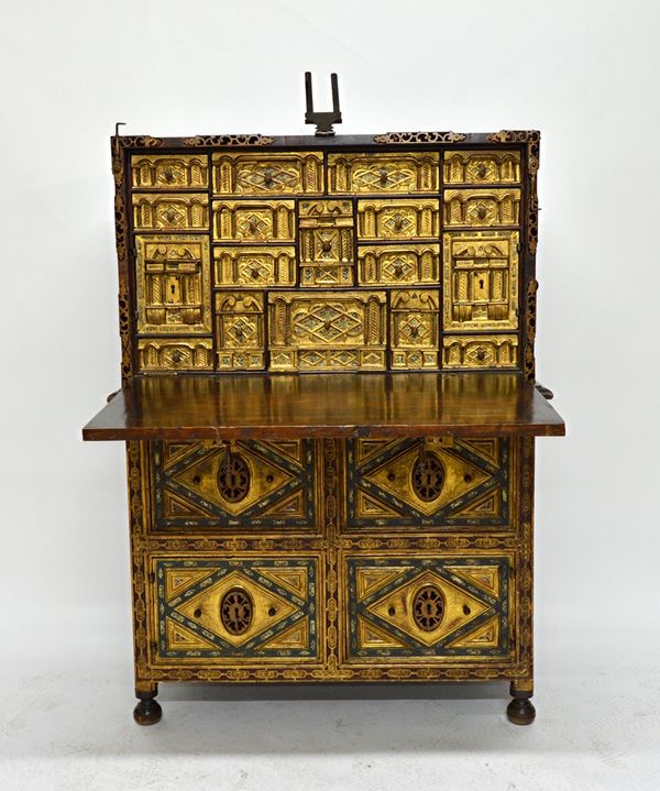 A 17th century style vargueno, the velvet backed gilt metal mounted front dropping to reveal an extensive fitted interior, the gold and green painted