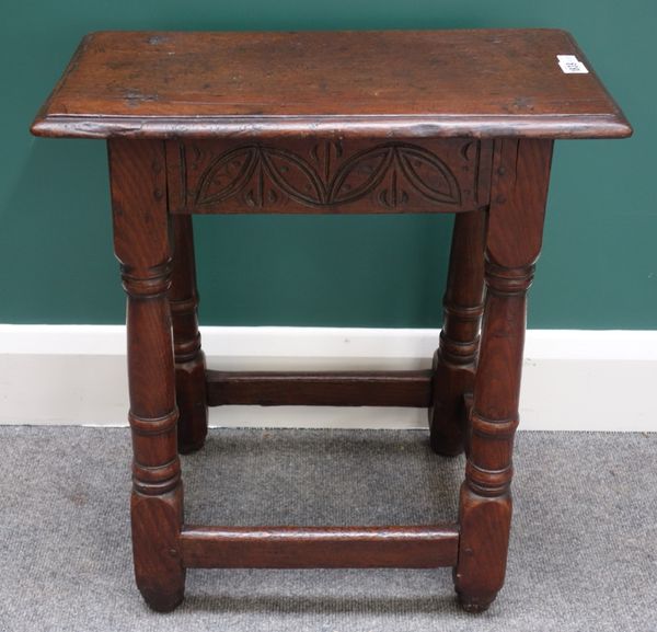 A 17th century oak joint stool on gun barrel turned supports, united by perimeter stretcher, 51cm wide.