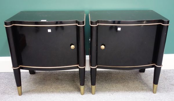 A pair of mid 20th century ebonised bedside tables, with bowed single door and sabre supports, resting on lacquered brass feet, 50cm wide (2).