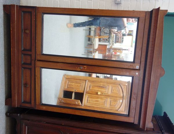 A 19th century Aesthetic Movement wardrobe, with pair of mirrored doors over two drawers, on shaped bracket feet, 139cm wide x 197cm high.