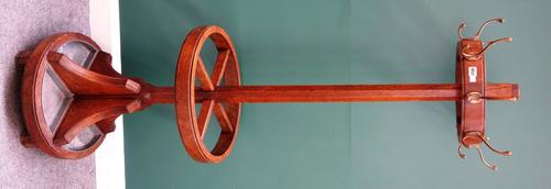 An early 20th century oak coat and umbrella stand, the halo ring mounted with eight coat hooks, on tapering octagonal column and four division stick s