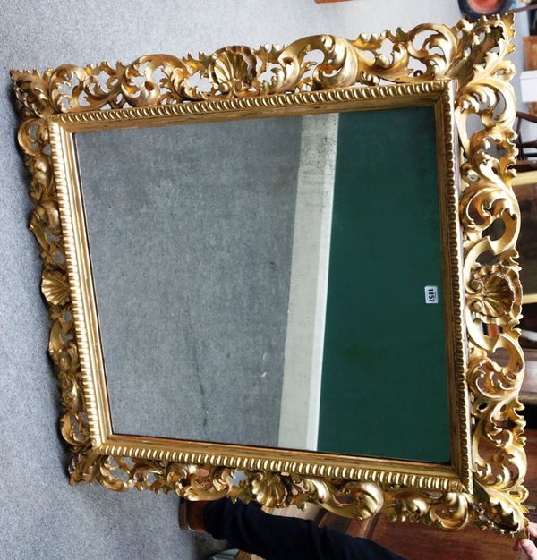 A Florentine gilt framed wall mirror, the acanthus carved frame with shell upper and lower mounts, 95cm wide x 108cm high.