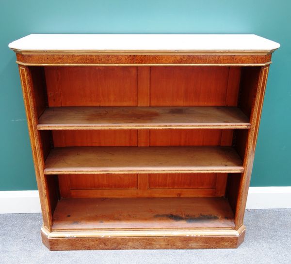 A late Victorian floor standing open bookcase, the marble top over a parcel gilt amboyna three tier base, 104cm wide.