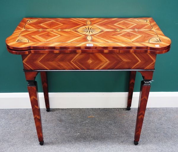 An 18th century Italian ebony, fruitwood and sycamore games table, the fold out rectangular top with outstepped rounded corners, on tapering square su