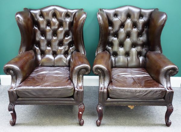 A pair of George II style wing back studded brown leather upholstered armchairs, on cabriole supports (2).