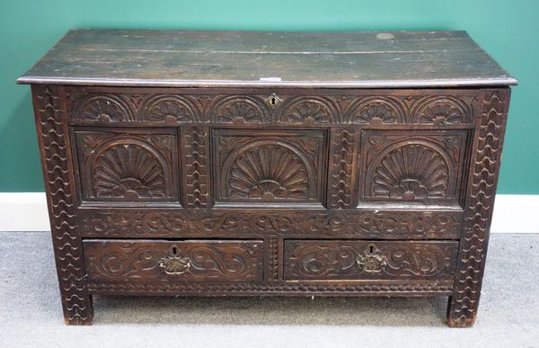 An 18th century carved oak mule chest, the lift top over triple panel front over a pair of drawers on stile supports, 123cm wide.