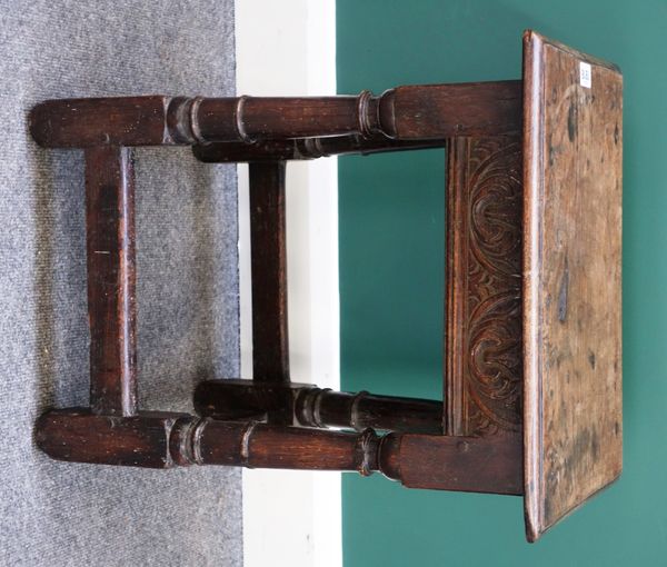 A Charles II and later oak joint stool, with carved frieze on ring turned supports, united by perimeter stretcher, 38cm wide.