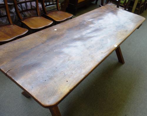 A 19th century elm tavern table of 17th century style, the single slab top on X frame supports, 64cm wide x 183cm long.