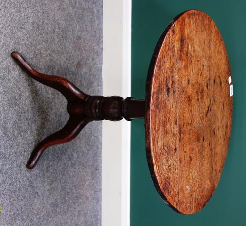 A diminutive 18th century oak tripod table, the circular snap top on turned column and three downswept supports, 46cm wide.