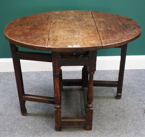 A 17th century oak drop flap table with single frieze drawer on baluster turned supports, 68cm wide, the top 3cm thick.