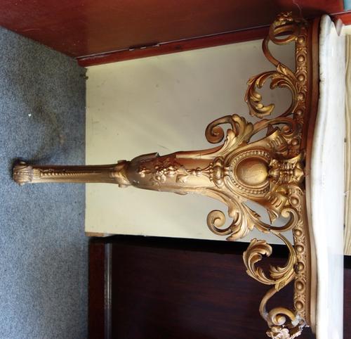 A late 19th century Italian Rococo Revival console table, the serpentine marble top over a pierced and carved gilt base, with single cartouche mounted