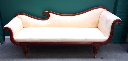 A William IV mahogany chaise lounge with shaped back and roll over ends on tapering reeded supports, 205cm wide.